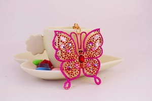 Gros plan détaillé du porte-clés papillon rose avec strass et fermoir mousqueton