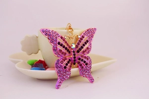 Gros plan détaillé d'un porte-clés papillon en strass violets avec fermoir doré