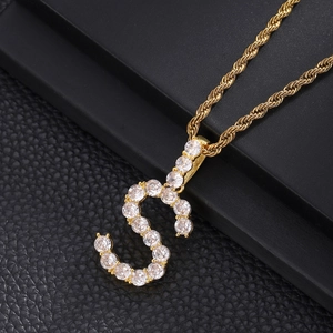 Close-up of hip hop letter S pendant with gold plating and paved zircon stones