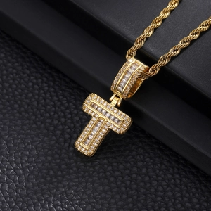 Macro detail of gold-plated hip hop pendant with baguette-cut zircons and twisted rope chain