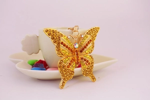 Gros plan du porte-clés papillon doré orné de strass ambrés et jaunes étincelants