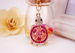 Macro shot of rhinestone turtle keychain with pink crystals and gold-plated lobster clasp