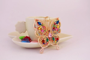 Gros plan d'un porte-clés papillon en strass colorés avec placage en or brillant