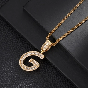 Macro detail of gold-plated G-letter pendant with pavé cubic zirconia on rope chain
