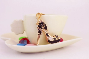 Détail du porte-clés escarpin avec strass et motifs d'étoiles accroché à une tasse