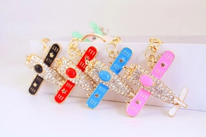 Detail of fighter plane keychains featuring sparkling rhinestones and colorful wings