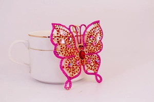 Gros plan détaillé d'un porte-clés papillon doré orné de cristaux roses brillants