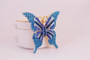 Détail de strass dégradés bleus et violets sur porte-clés papillon avec cadre doré