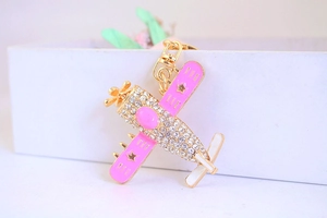 Detailaufnahme des pinkfarbenen Flugzeug-Schlüsselanhängers mit glitzernden Strasssteinen