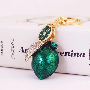 Sparkling lemon fruit keychain with green enamel finish and white rhinestone leaf detail
