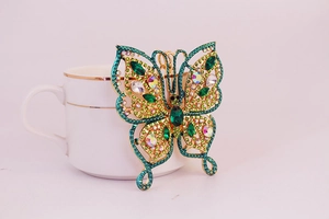 Détail du porte-clés papillon en pierre précieuse vert émeraude avec placage or et strass