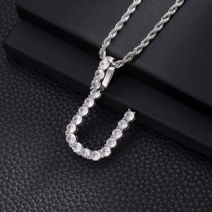 Macro shot of silver hip hop J-letter pendant with pavé cubic zirconia on rope chain