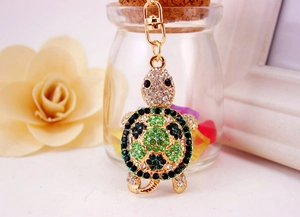 Detailed close-up of a sparkling turtle keychain with green and black rhinestones