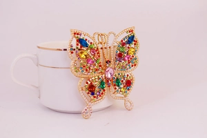 Détail du porte-clés papillon avec cristaux colorés et finition en métal doré
