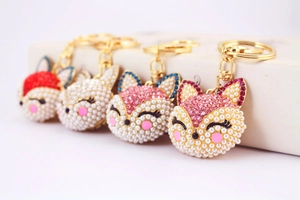 Détail de porte-clés renard avec têtes en perles, strass colorés et fermoirs dorés