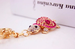 Macro side view of pink rhinestone crystal turtle keychain with gold alloy lobster clasp