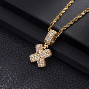Macro shot of hip hop cross pendant with gold plating and iced out cubic zirconia stones