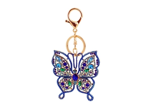 Détail du porte-clés papillon orné de strass bleus et verts avec fermoir en métal doré