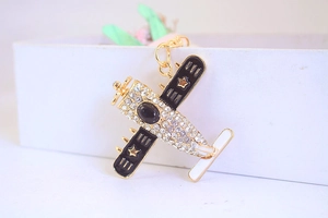 Detailaufnahme eines Vintage-Flugzeug-Schlüsselanhängers mit Vergoldung und Strass