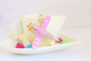 Pink rhinestone fighter plane keychain with gold alloy base and star wing detail