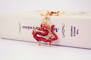 Close-up of red enamel and gold Chinese dragon keychain with premium swivel clasp