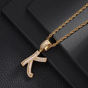 Macro shot of hip-hop letter K pendant with cubic zirconia on a gold rope chain