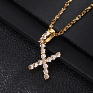 Macro shot of gold hip hop necklace featuring letter X pendant with clear zircons