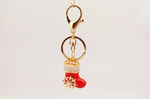 Détail de porte-clés botte de Noël en émail rouge avec strass et motif flocon de neige