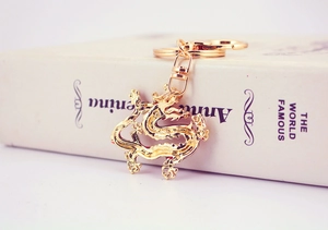 Detail of golden dragon keychain in alloy material on a book background decoration