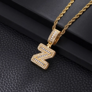Macro view of gold Z-letter pendant with baguette and round-cut cubic zirconia crystals