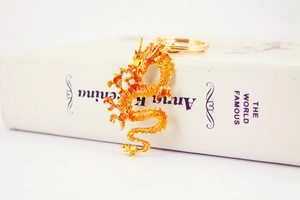 Detailed macro view of golden Chinese dragon keychain with intricate scales and metallic luster