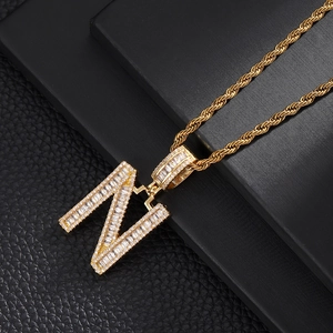 Macro shot of gold letter N pendant with micro-pave cubic zirconia on twisted rope chain