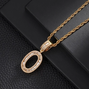 Macro detail of gold letter O pendant with baguette cubic zirconia on twist rope chain
