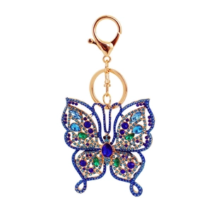 Porte-clés papillon exquis avec strass bleus et placage doré sur fond blanc pur