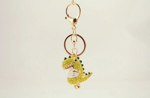 Detail of cute rhinestone dinosaur keychain with yellow crystals and golden clasp