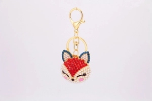 Détail d'un porte-clés renard avec tête en cristal rouge et visage en perles imitation