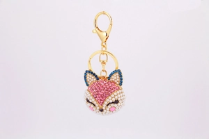 Détail du porte-clés renard avec strass roses bleus et perles blanches sur alliage doré