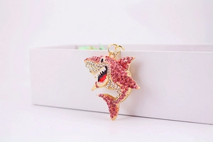 Vue détaillée d'un porte-clés requin avec strass roses et blancs sur support doré