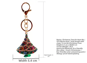 Close-up of golden Christmas tree keychain with green enamel and sparkling crystals