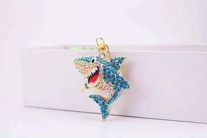 Vue détaillée d'un porte-clés requin en strass bleus avec mousqueton doré élégant