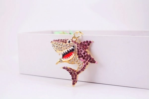 Détail macro du porte-clés requin avec strass violets et artisanat en émail complexe