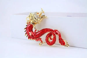 Detail of dragon keychain with red enamel, golden finish and sparkling rhinestones