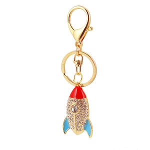Porte-clés fusée étincelant avec strass blancs et émail rouge bleu sur métal doré