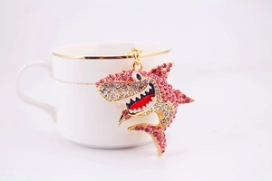 Gros plan d'un porte-clés requin étincelant avec strass sur une tasse à café élégante
