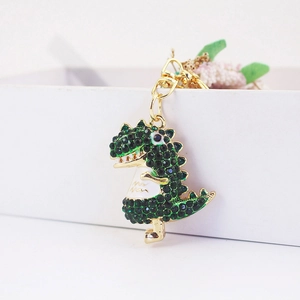 Cute rhinestone dinosaur keychain featuring green crystals and a golden lobster clasp