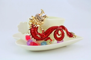 Detailed macro view of an ornate red enamel dragon brooch with crystal embellishments