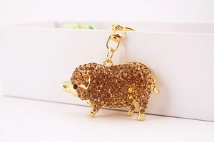 Détail du porte-clés cochon doré étincelant orné de strass ambrés et fermoir dorée