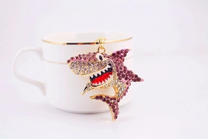 Détail macro du porte-clés requin en strass violets sur une tasse en porcelaine
