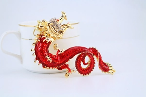 Macro detail of Chinese zodiac dragon keychain with red enamel and gold finish