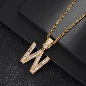 Macro shot of gold hip-hop letter W pendant with baguette-cut zircons and rope chain